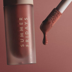 Summer Fridays lip oil in hand for scale showing compact travel-friendly size