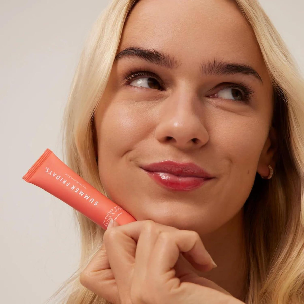 Summer Fridays swatch on hand showing sheer poppy tint and healthy shine benefit