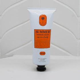 Summer Tanning Gelée bottle staged poolside conveying beach-ready protection and glow