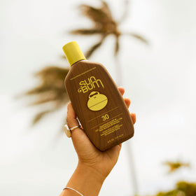 Sun Bum applying sunscreen to arm demonstrating easy coverage and water resistance