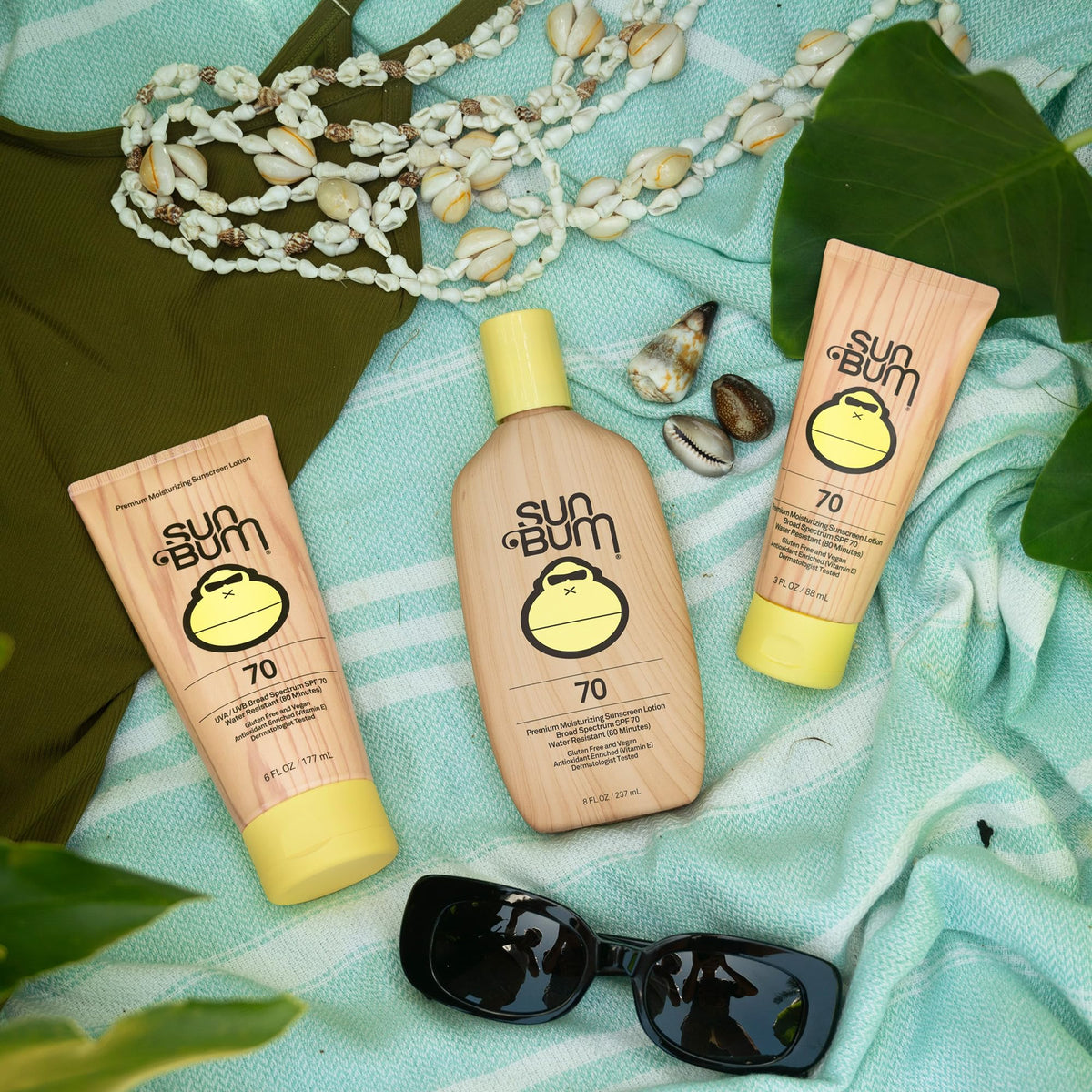 Sun Bum SPF 70 8 oz bottle beside common items for size comparison and portability