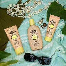 Sun Bum SPF 70 8 oz bottle beside common items for size comparison and portability