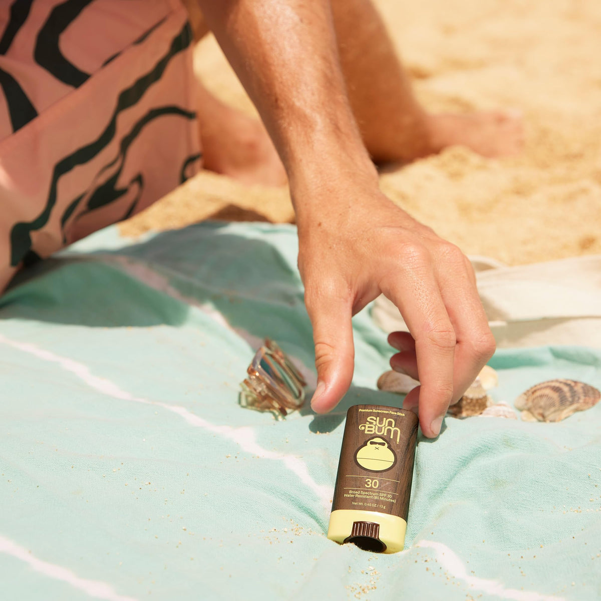 Sun Bum spray dispensing sunscreen over arm, fast even coverage benefit