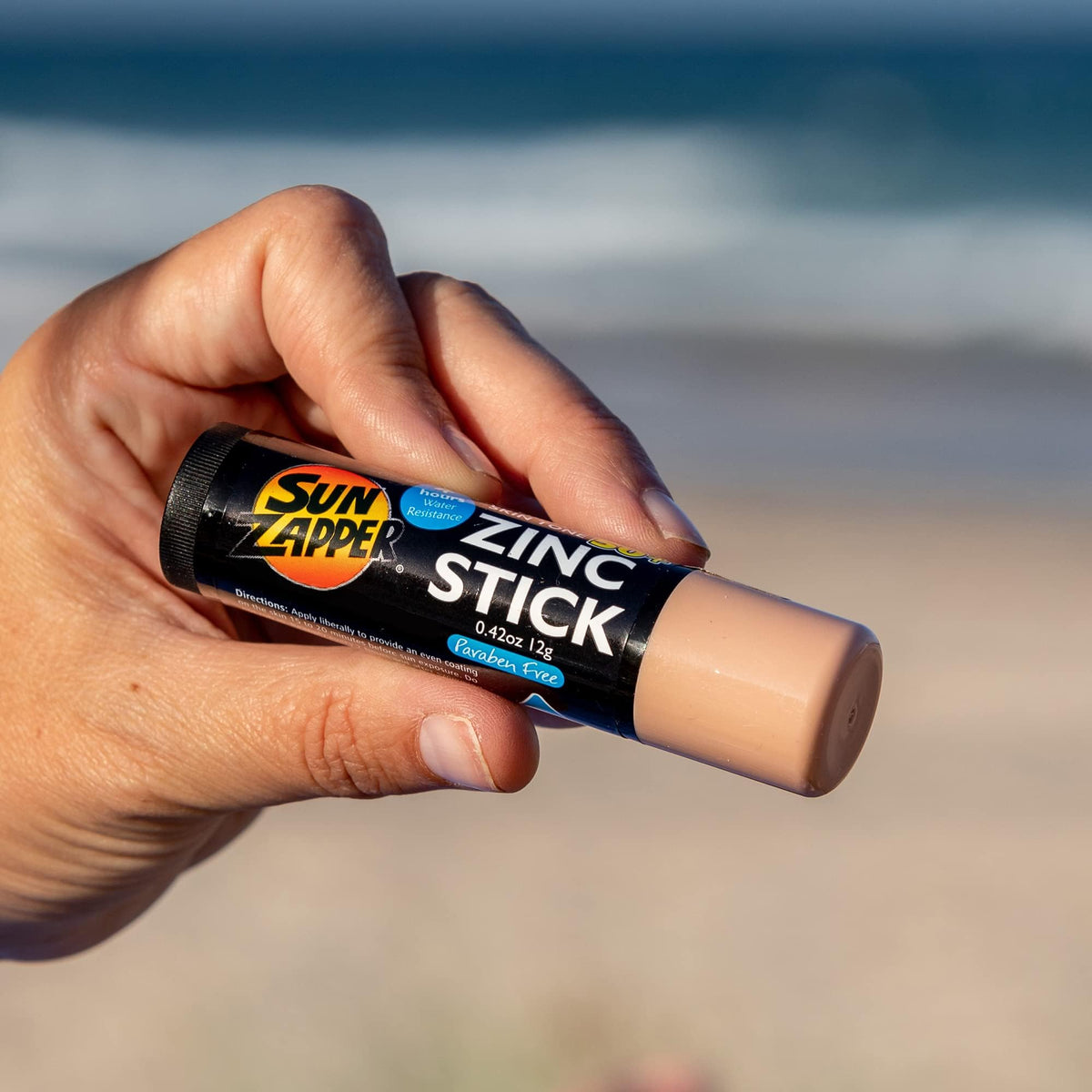 Sun Zapper held in hand to show 12g travel-size portability and ease