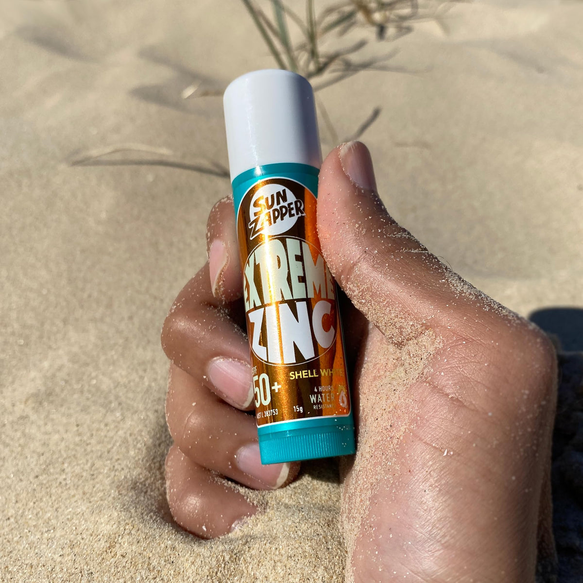 Surfer applying Sun Zapper on beach showing durable protection during surf
