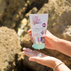 Sunshine & Glitter next to passport and sunscreen for travel convenience