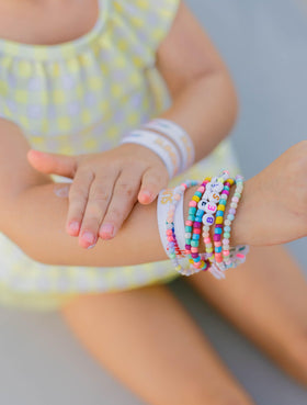 Sunshine & Glitter applied to child at beach promoting playful sun safety