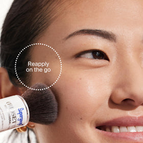 Supergoop! compact in hand to show travel-ready size and portability