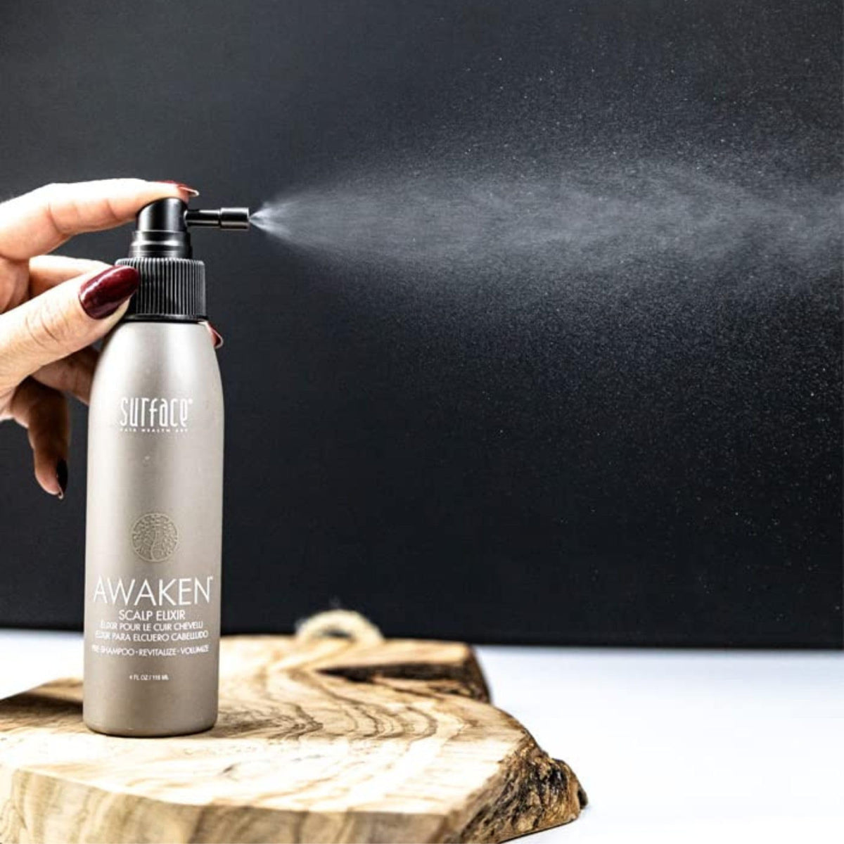 Surface Awaken bottle held in hand showing 4 fl oz size for scale