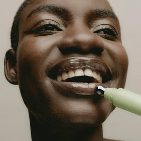 SWEET JULY balm applied from tube in hand showing effortless, non-sticky glide