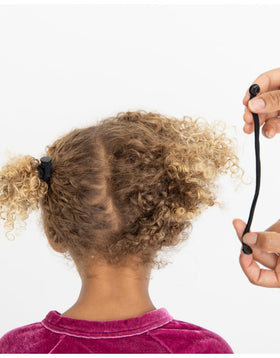 swirlycurly hair tie securing a protective bun reducing tension on curls