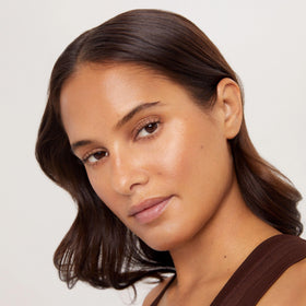 TAN-LUXE bottle on bedside table as part of nighttime skincare routine