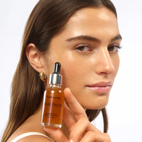 TAN-LUXE bottle beside coin for scale, compact travel-friendly size