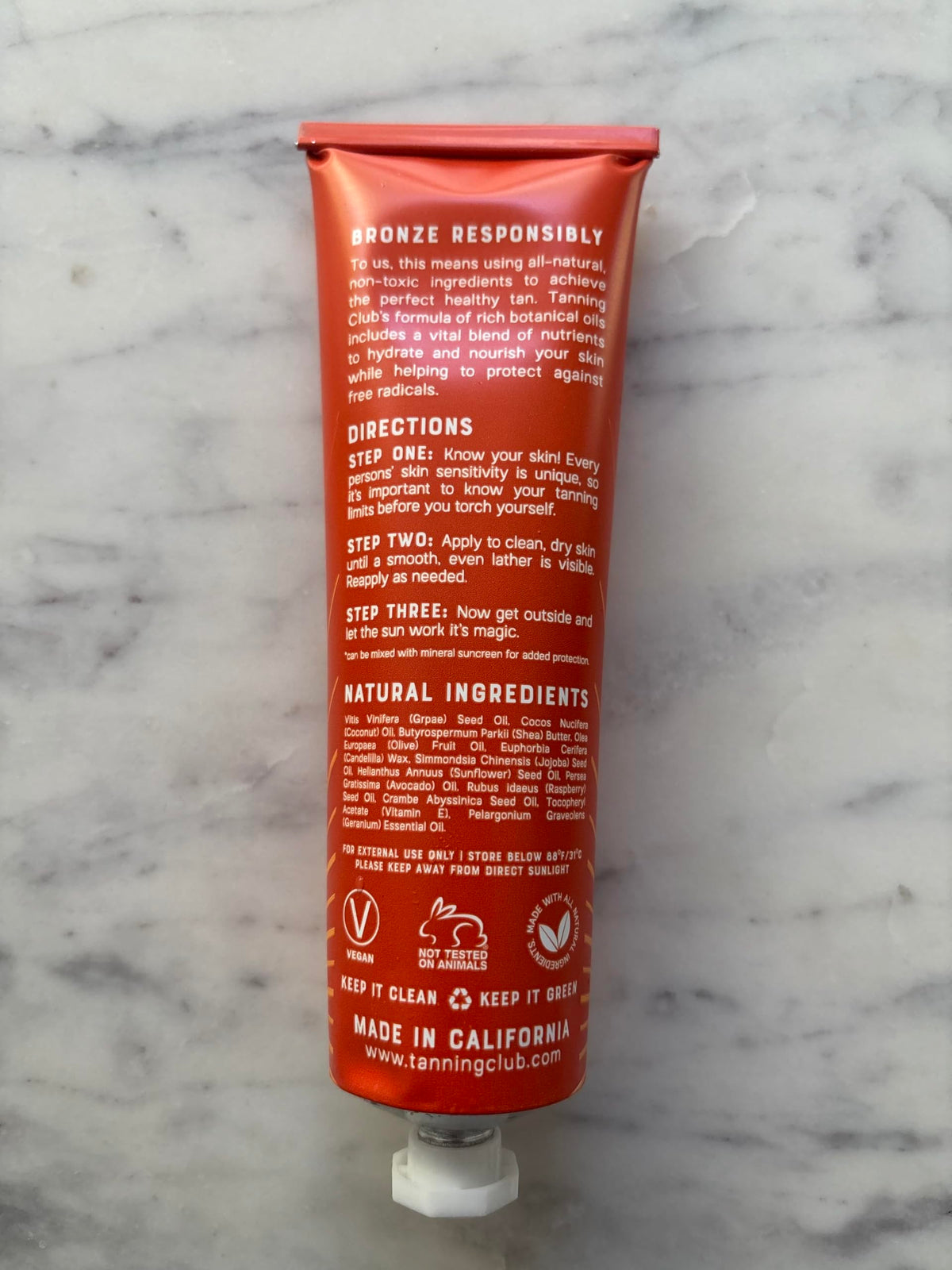 Tanning Club balm in beach setting illustrating outdoor tanning support benefit