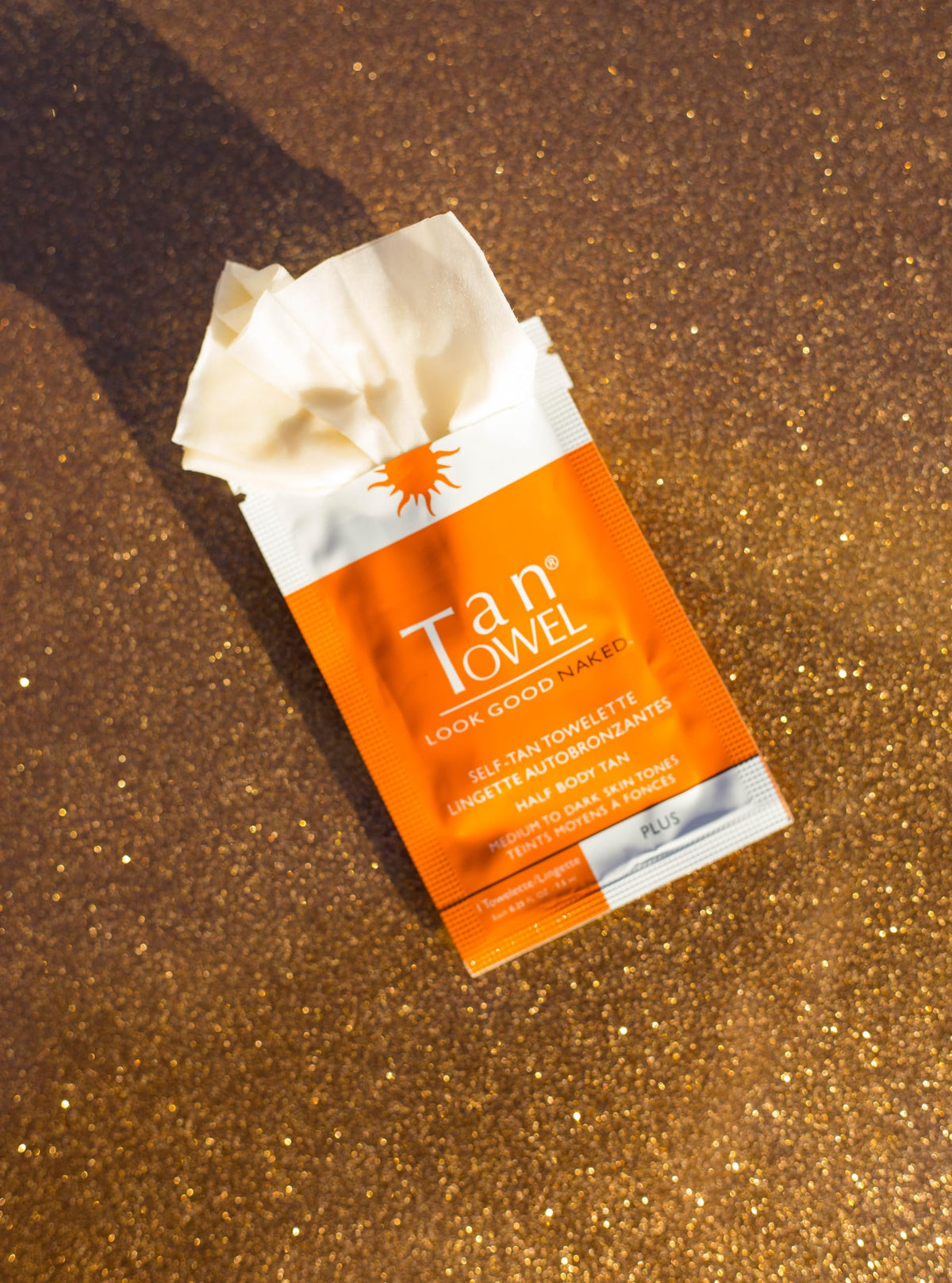 TanTowel wipe being applied to forearm demonstrating streak-free, easy blend