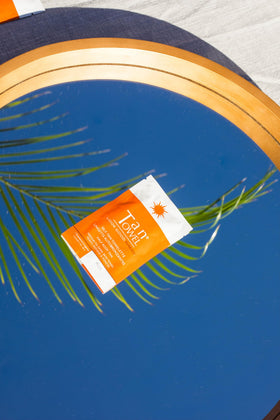 TanTowel half-body wipe next to hand showing size for efficient limb coverage