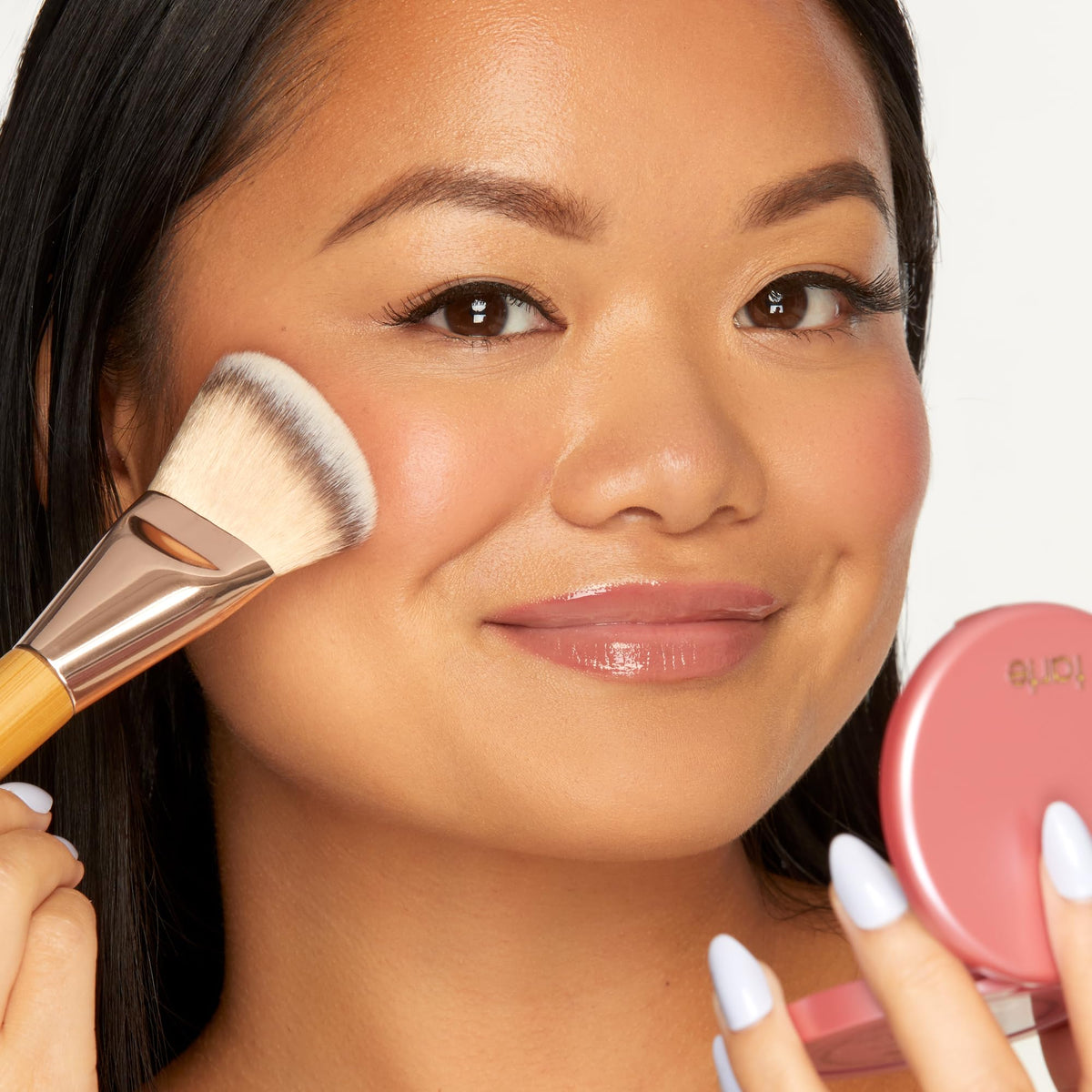 tarte compact beside coin for scale, shows full-size practical portability