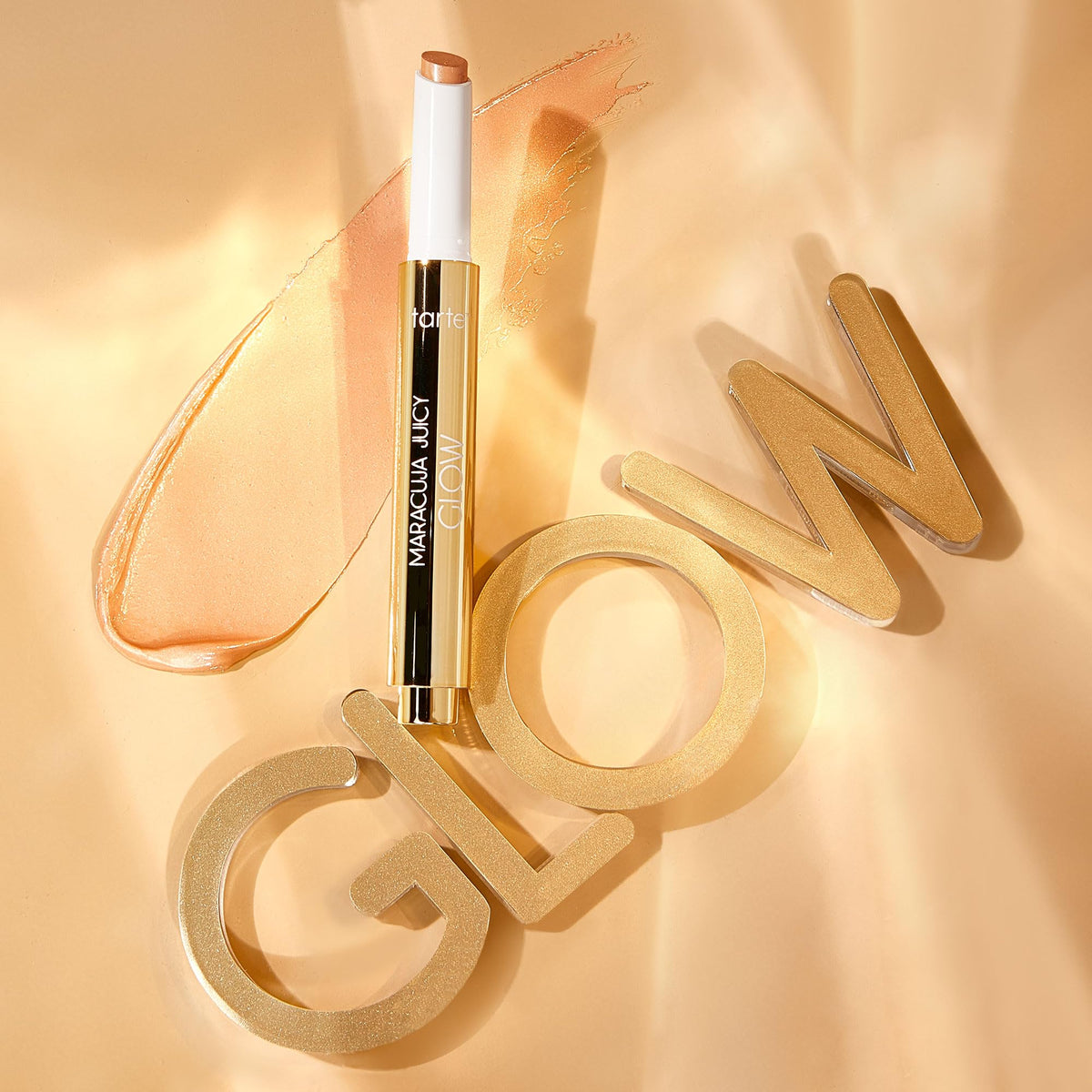 tarte pen held next to fingers showing compact, travel-friendly size