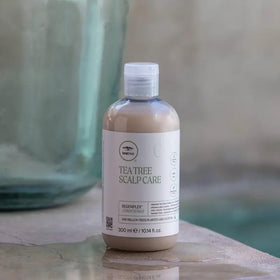 Tea Tree bottle in hand to show scale and easy dispensing for convenience