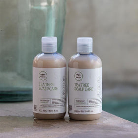 Tea Tree conditioner being applied in shower to detangle and strengthen hair