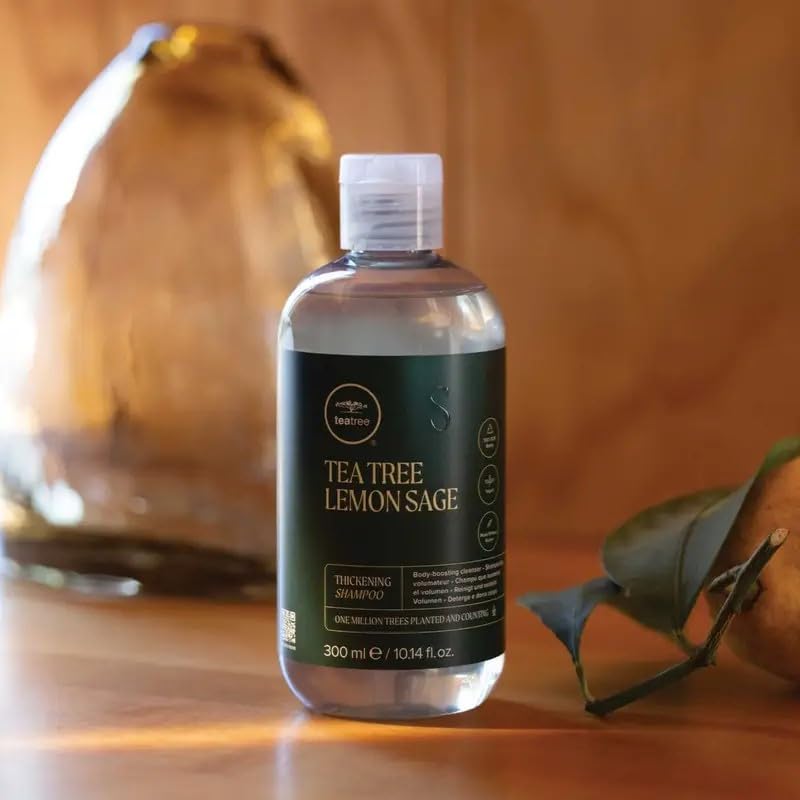 Tea Tree 33.8 fl oz bottle next to hand for clear size comparison