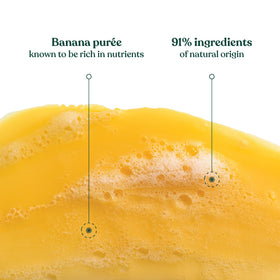 Hand holding The Body Shop banana shampoo bottle showing 8.4 oz scale for size clarity