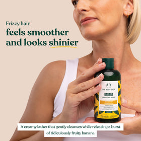 The Body Shop banana shampoo displayed with banana and leaves conveying natural moisture