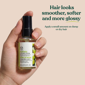 Hand holding The Body Shop serum for scale and easy dosing to show small travel-friendly size