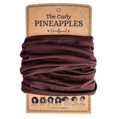 The Curly Pineapples front packaging displaying chocolate brown headband and benefit