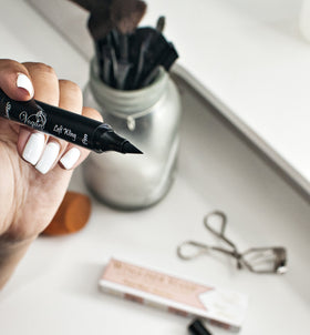 The Flick Stick in a makeup bag lifestyle shot showing convenience on the go