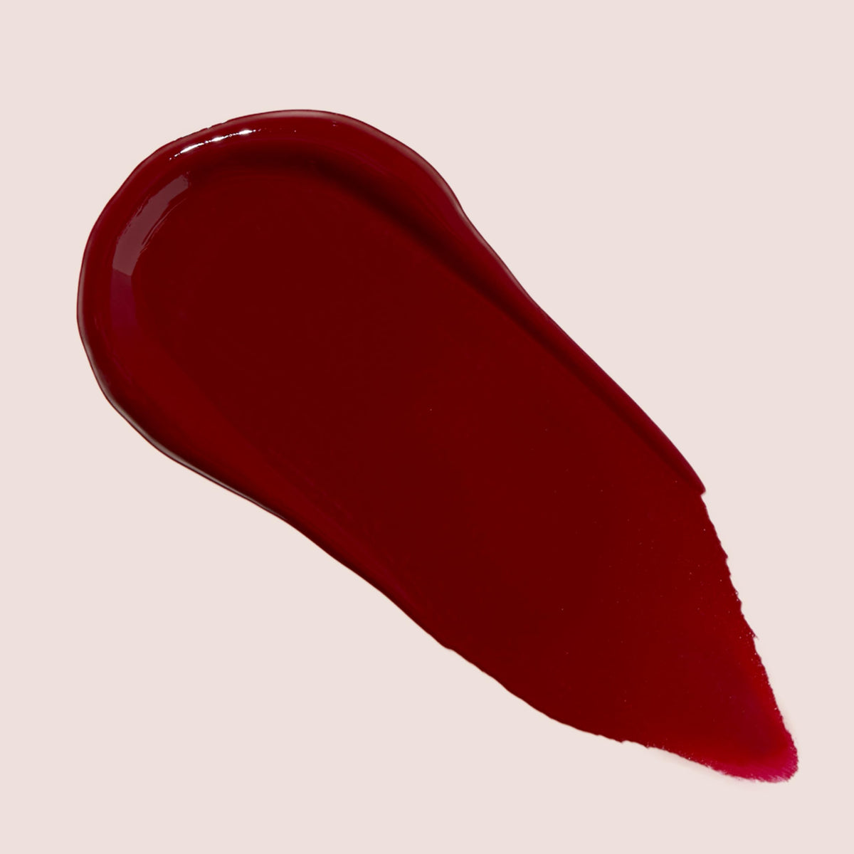 The Lip Bar Gamechanger gloss swatch on hand showing sheer nude glow