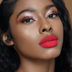 The Lip Bar lipstick beside a coin showing .24 fl oz size and travel-friendly benefit