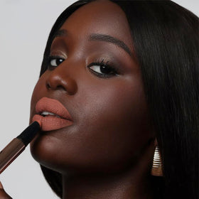 The Lip Bar swatch on wrist showing Muse deep berry payoff and blendable finish