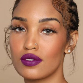 The Lip Bar Prima Donna color swatch on arm conveying high pigment and even coverage