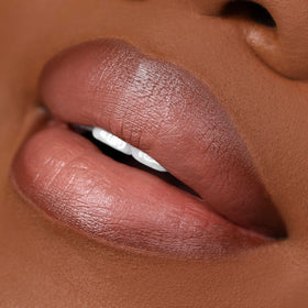 Hand holding The Lip Bar liner for scale, showing compact size and travel convenience