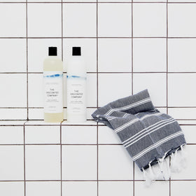 Shampoo bottle on bathroom shelf in use scene by The Unscented Company for natural look