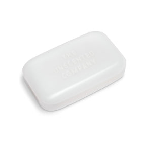 Hand holding a single The Unscented Company soap bar to show size and easy grip for bathing