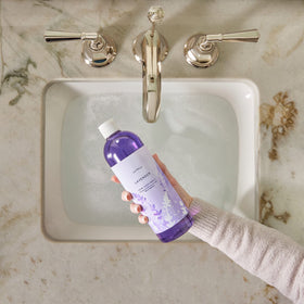 Thymes lavender refill being poured into a pump dispenser for easy replenishing