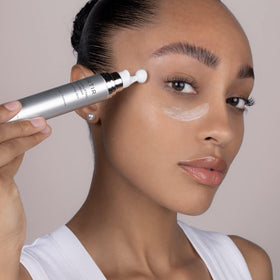 Model applying TIRTIR under-eye with roller to reduce puffiness and smooth skin