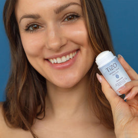 TIZO mineral stick being applied to face demonstrating easy, mess-free on-the-go benefit