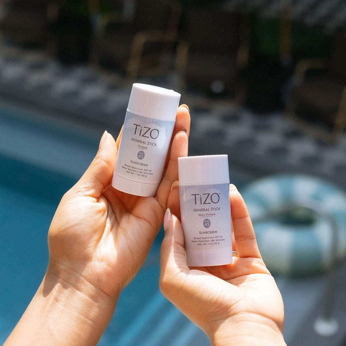 TIZO mineral stick on a beach towel in lifestyle scene highlighting water resistant benefit