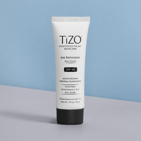 TIZO tube next to scale showing 1.75 oz size for travel convenience