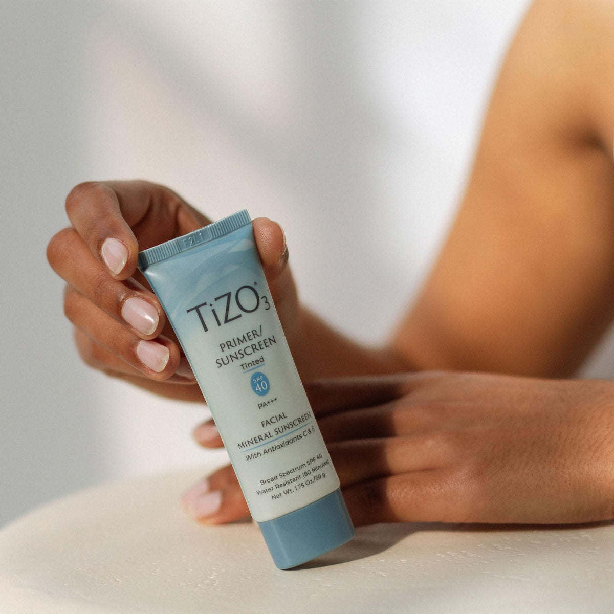 TIZO size comparison next to a lipstick to show 1.75 oz travel-friendly volume