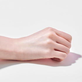 TOCOBO tube next to hand for scale showing compact everyday size