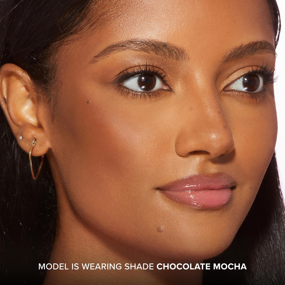 Too Faced bronzer stick held in hand showing compact size and portability