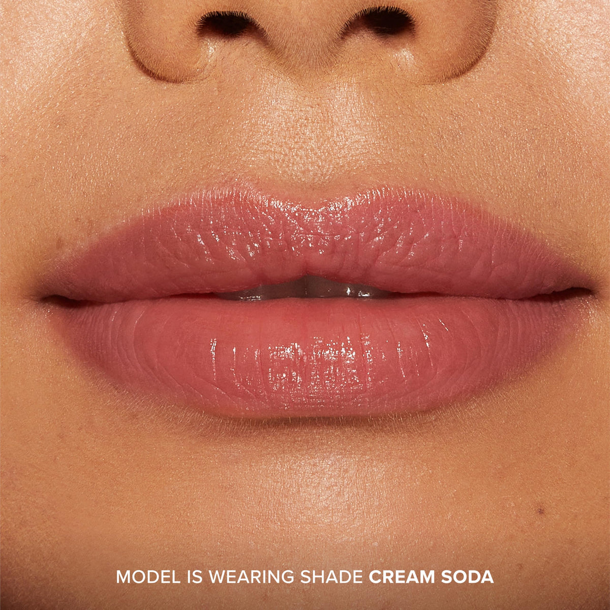 Too Faced closeup on lips wearing Cream Soda tint showing hydrated, shiny result