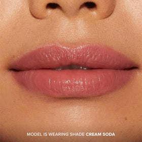 Too Faced closeup on lips wearing Cream Soda tint showing hydrated, shiny result