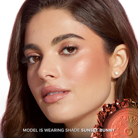 Too Faced compact in hand illustrating travel-friendly scale and portability