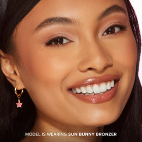 Too Faced Sun Bunny beside coin to show compact size and easy storage