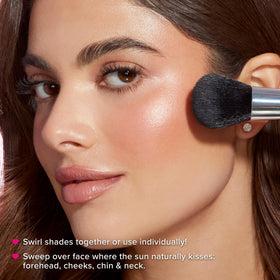 Too Faced brush with swirled product showing unified luminous finish for cheeks